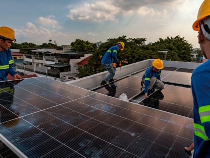 Workers from solar company Solva Energy install solar panels on the roof of a house on July 6, 2026, in Antipolo, Philippines.