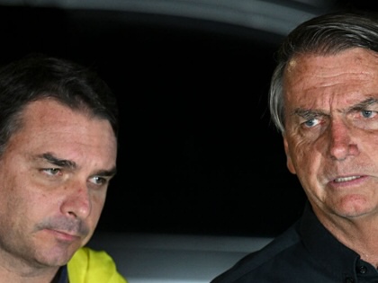 Jair Bolsonaro speaks next to his son Flávio in Brasilia, on October 2, 2022.