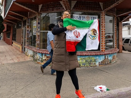 A soccer fan in Tijuana, Mexico, holds a flag of Iran and Mexico and bids farewell to the players of Iran after it participated in the 2026 World Cup.