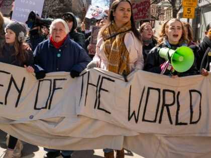 Demonstrators hold signs during a march honoring International Women’s Day on March 8, 2025, in New York City.