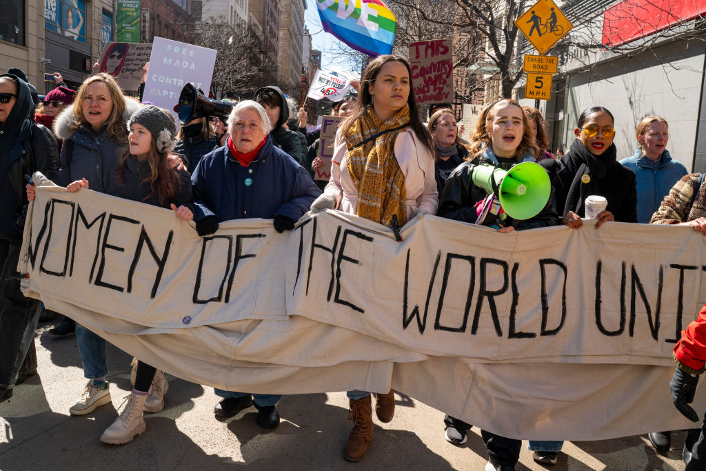 Demonstrators hold signs during a march honoring International Women’s Day on March 8, 2025, in New York City.