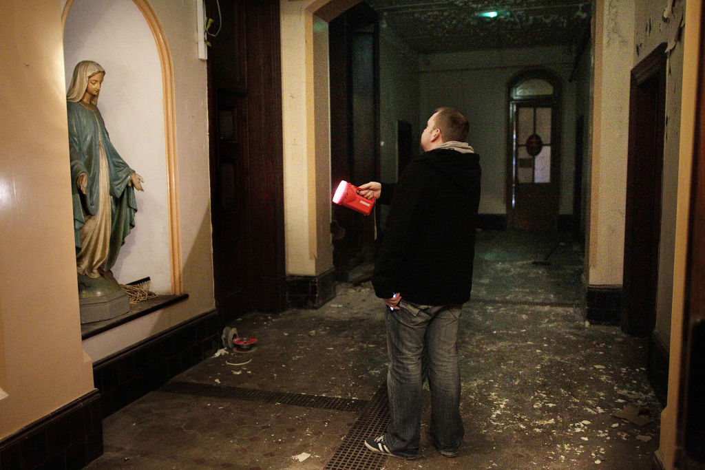 A Dublin City Council worker shines a torch in the corridor of the now derelict Sisters of Our Lady of Charity Magdalene Laundry on Sean McDermott St in Dublin’s north inner city on May 2, 2013.