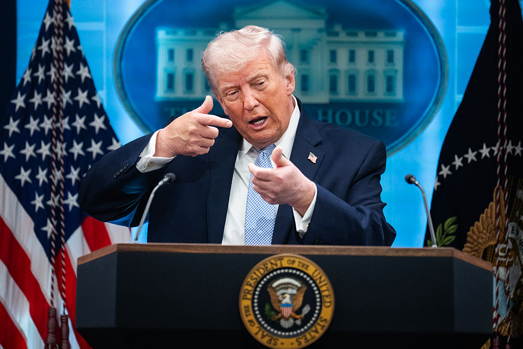 Donald Trump mimics firing a gun during a news conference in the White House briefing room about the war in Iran on April 6, 2026.