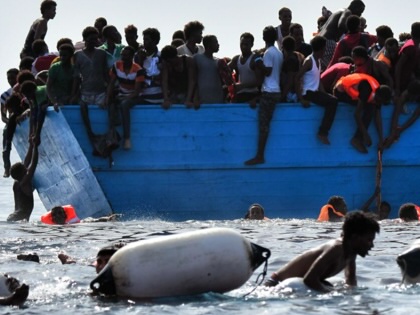 Migrants wait to be rescued by members as they drift in the Mediterranean Sea, some 12 nautical miles north of Libya, on October 4, 2016.