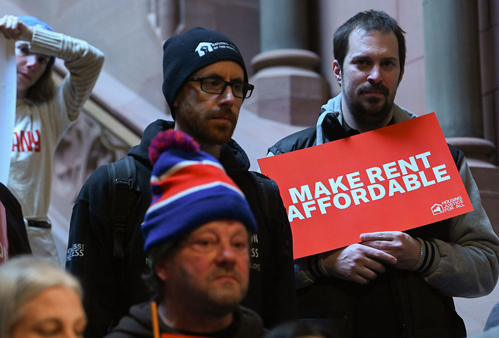 People hold signs as tenant advocates and lawmakers hold a rally at the New York State Capitol to unveil a Make Rent Affordable platform in Albany, New York, on January 27, 2026.