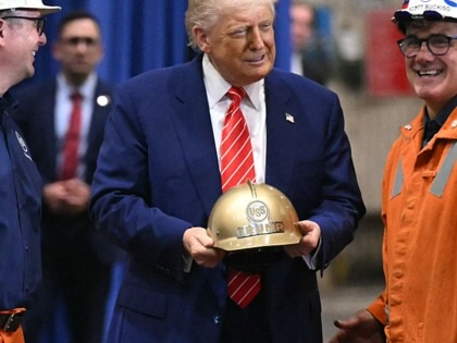 Donald Trump receives a gold helmet with his name on it during a visit to US Steel - Irvin Works in West Mifflin, Pennsylvania, on May 30, 2025, to mark the deal between Nippon Steel and US Steel.