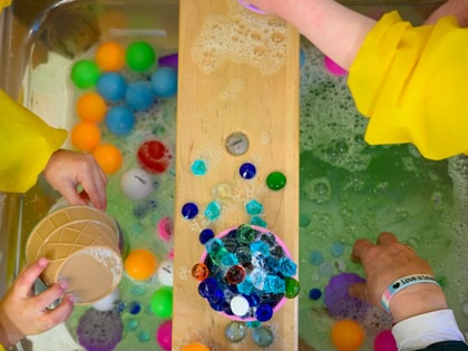 Students play with toys in a basin of soapy water at the Connecticut State University Early Learning Center on March 12, 2025, in New Britain, Connecticut.