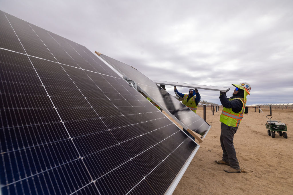 Workers install solar panels for the Los Angeles Department of Water and Power's biggest solar and battery storage plant, the Eland Solar and Storage Center in the Mojave Desert of Kern County on Monday, November 25, 2024, near California City, California.