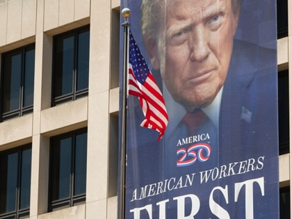  A banner reading "American Workers First" with a portrait of Donald Trump is displayed on the front of the US Department of Labor Frances Perkins Building.