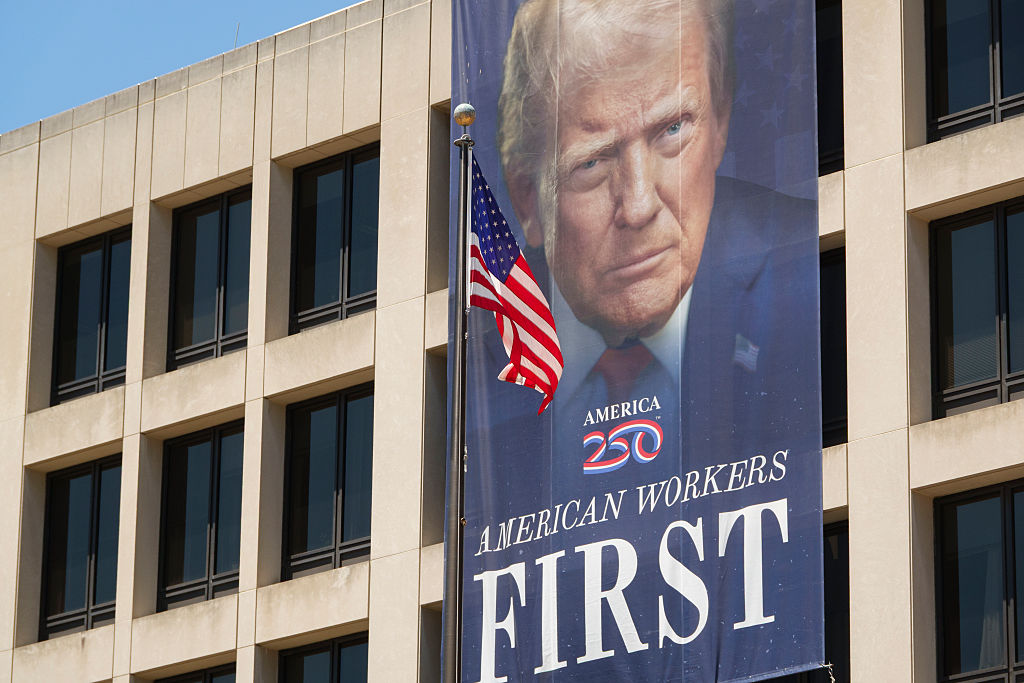  A banner reading "American Workers First" with a portrait of Donald Trump is displayed on the front of the US Department of Labor Frances Perkins Building.