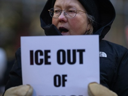 A demonstrator holds a protest sign ("ICE out of MPLS"), calling for an end to ICE operations in Minnesota, outside of Senator Amy Klobuchar's  office in Minneapolis, on January 26, 2026.