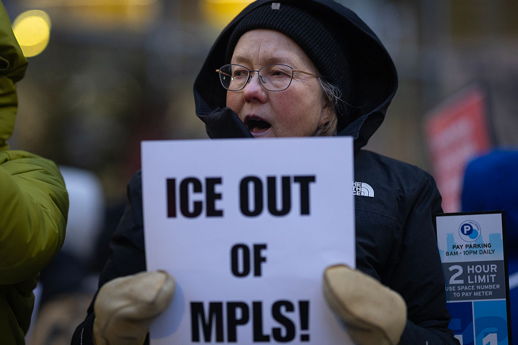 A demonstrator holds a protest sign ("ICE out of MPLS"), calling for an end to ICE operations in Minnesota, outside of Senator Amy Klobuchar's  office in Minneapolis, on January 26, 2026.