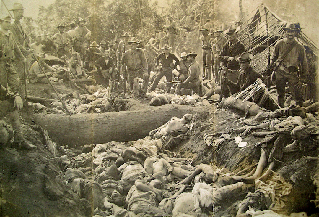 US soldiers pose with massacred Moro people at Bud Dajo in the Philippines, 1906.