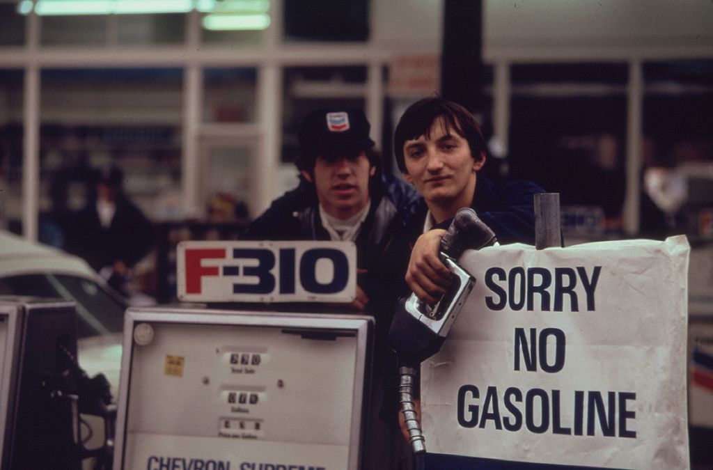 Gas station attendants peer over their "Out of gas" sign in Portland, one day before the state's requested Saturday closure of gasoline stations in 1973.