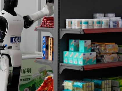 Robots simulate working on small supermarket shelves during the 2026 World Humanoid Robot Games in Beijing, China.