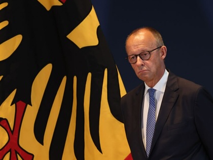 German Chancellor Friedrich Merz stands next to a flag showing the German federal eagle as he attends the dismissal and confirmation ceremony of government cabinet members on July 29, 2026, in Berlin, Germany. 