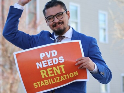 A campaign photo of David Morales holding a sign advocating rent stabilization.