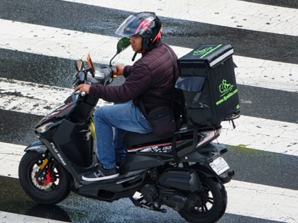 A food delivery worker rides through an intersection on May 31, 2025, in Washington, DC.