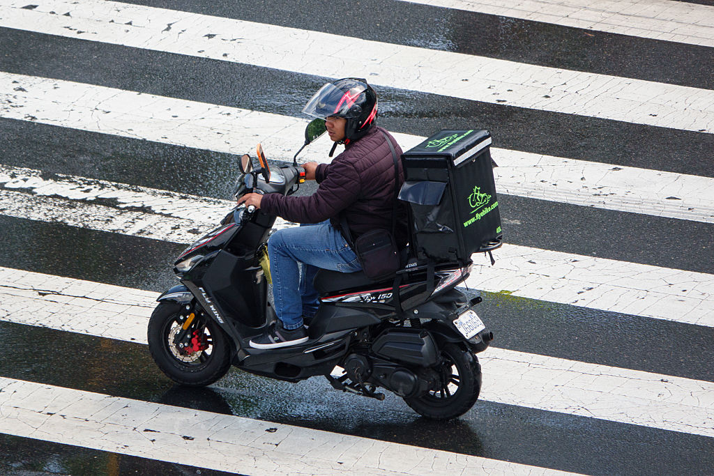 A food delivery worker rides through an intersection on May 31, 2025, in Washington, DC.