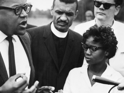 James Lawson (left), a spokesperson for the Freedom Riders, holds an impromptu press conference in Alabama just before the bus carrying the integration group crossed the state line into Mississippi.