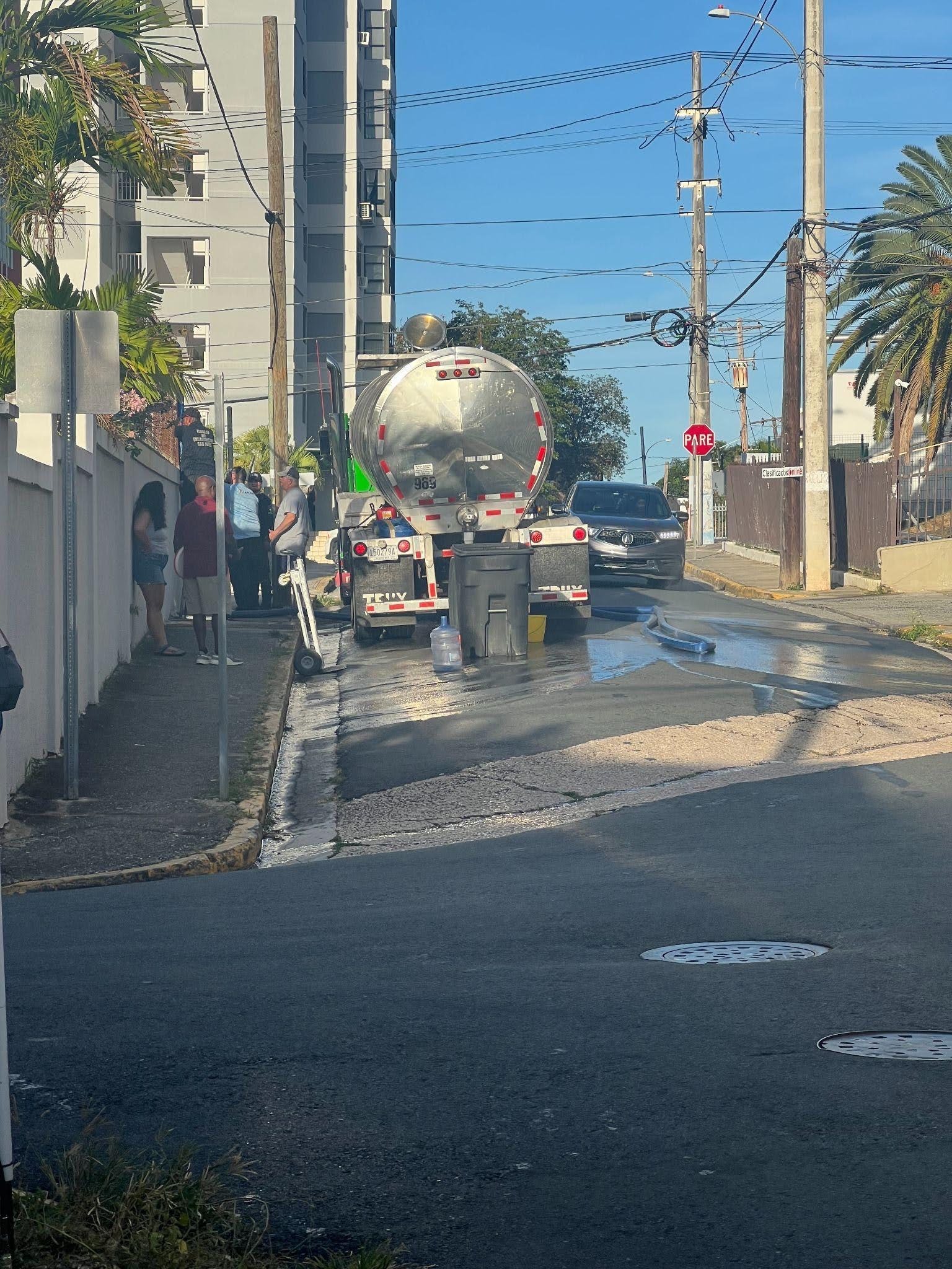 Residents of Santurce, San Juan, line up at the water oasis on June 16, 2026.