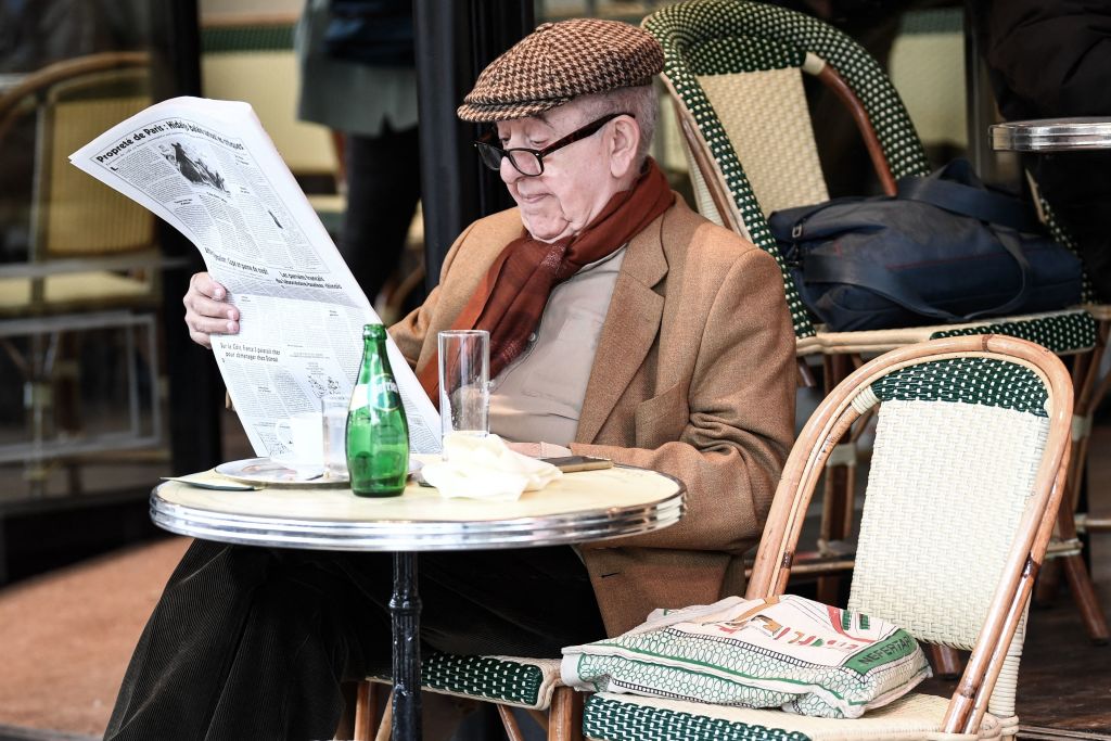 A man reads a newspaper on the terrace of Paris's landmark Café de Flore on May 19, 2021.