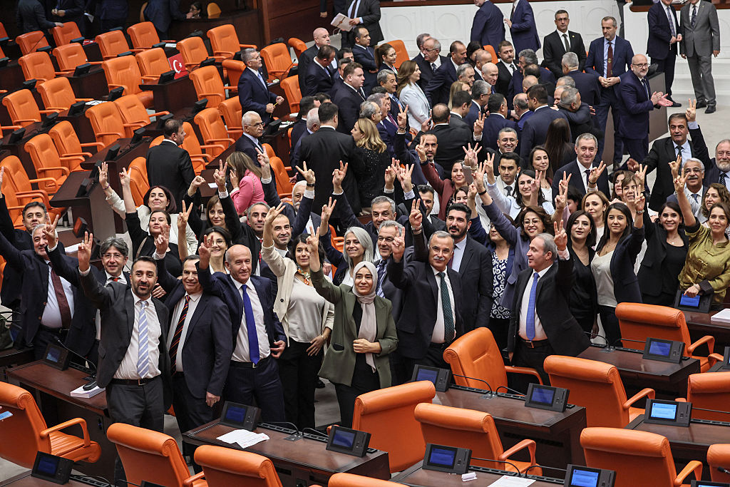Equality and Democracy (DEM) Party lawmakers make the victory sign after voting for a bill offering limited amnesty for Kurdish PKK militants at the Grand National Assembly of Turkey in Ankara on August 10, 2026.