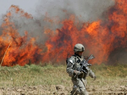 A US soldier crosses a field after burning down the undergrowth during a clearing operation outside Baquba, on October 9, 2007, some 50 kilometers northeast of Baghdad, Iraq.
