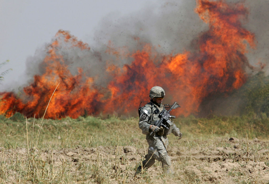 Un soldado estadounidense cruza un campo tras quemar la maleza durante una operación de limpieza en las afueras de Baquba, el 9 de octubre de 2007, a unos 50 kilómetros al noreste de Bagdad, Irak.