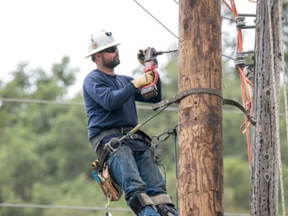 A PG&amp;E worker drills a hole into a power pole in Yountville, California,  on April 29, 2020. 