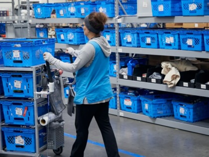 An employee gathers online orders at a Walmart market fulfillment center in the back of a store in Grapevine, Texas, on October 10, 2023. 